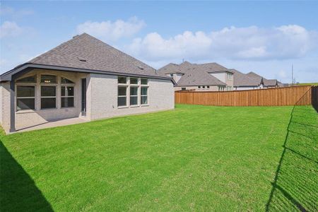 Rear view of house with a yard and a patio