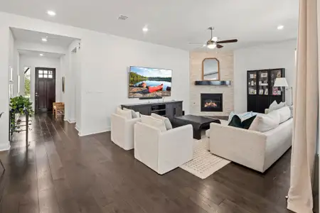 Living room with dark wood-type flooring, recessed lighting, a fireplace, and visible vents