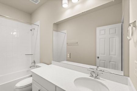 The secondary bath features tile flooring, white cabinetry and light countertops and a shower/tub combo. Perfect for accommodating any visiting family and friends.