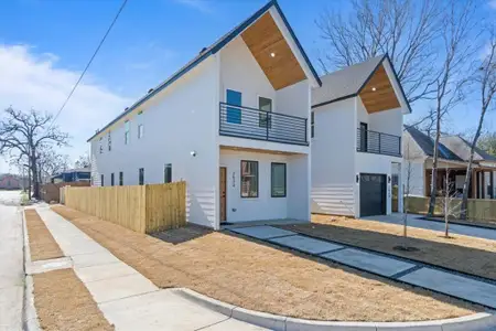 View of front of property featuring a balcony, fence, concrete driveway, and stucco siding