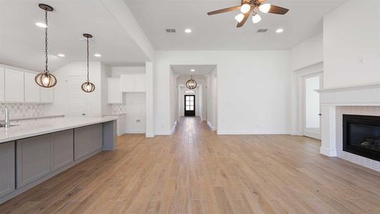 Kitchen with light hardwood / wood-style floors, decorative backsplash, and a fireplace