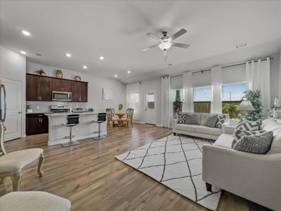 Living room with ceiling fan and light hardwood / wood-style floors