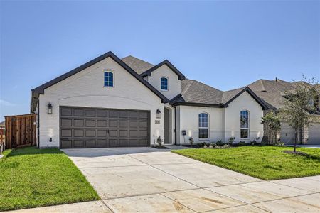 French country style house with a front lawn and a garage