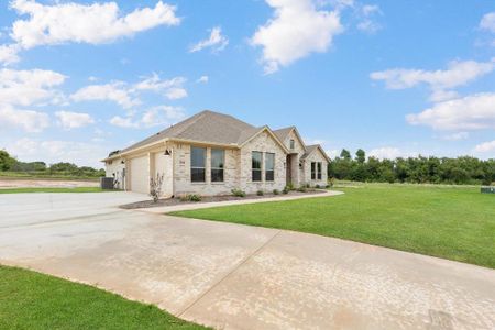 View of front of property with central air condition unit, a front yard, and a garage