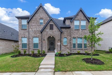 View of front of house with brick siding and a front lawn