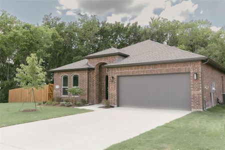 View of front of property featuring a garage and a front lawn