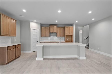 This kitchen is by far any chef’s dream! This spacious kitchen features high ceilings, stained wood cabinets, quartz countertops, SS appliances, modern tile backsplash, recessed lighting, quartz kitchen island with space for breakfast bar and extra storage, and a walk-in pantry all overlooking your huge family room.