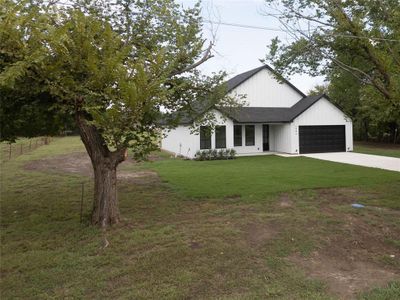 View of front of home with a garage and a front lawn