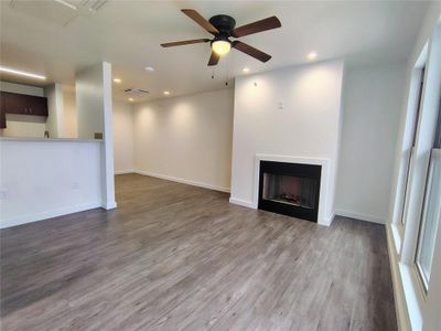 Unfurnished living room featuring hardwood / wood-style floors and ceiling fan