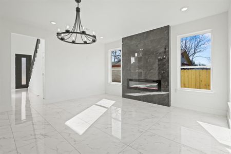 Dining space featuring a tiled fireplace and a notable chandelier