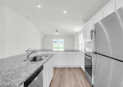 Stunning kitchen with white cabinets, stainless steel appliances and granite countertops