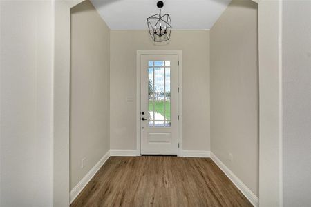 Entryway featuring hardwood / wood-style flooring and a notable chandelier