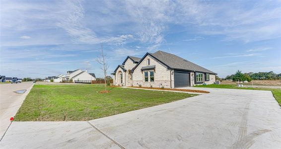 View of front of home featuring a front lawn and a garage