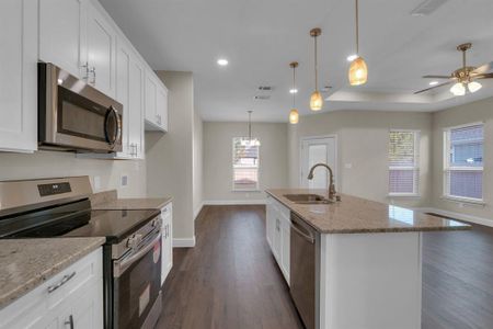 Kitchen with a center island with sink, appliances with stainless steel finishes, and white cabinetry