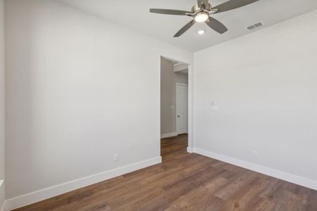 Unfurnished room featuring dark wood-type flooring and ceiling fan