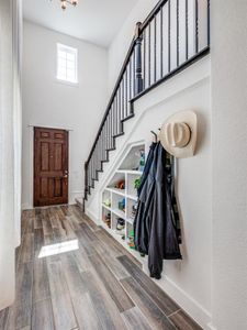 Entrance foyer with wood finished floors, stairway, and a towering ceiling Entrance foyer with wood finished floors, stairway, and a towering ceiling