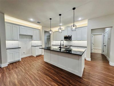 The kitchen features a sizable island, which is great for cooking, dining, and hosting guests. It's designed with entertaining in mind.