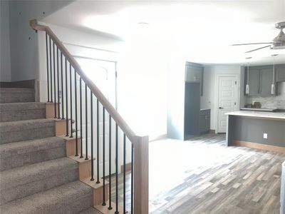 Staircase featuring ceiling fan and hardwood / wood-style floors