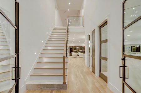 FOYER:  Dramatic two story space with elegant marbled first step and glass balustrade with stair lighting accents.  Touch one of the paneled doors under the staircase and you’ll find perfect place for holiday storage or golf clubs.