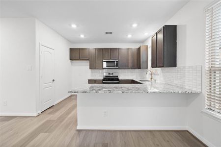 This kitchen is by far any chef’s dream! This spacious kitchen features high ceilings, stained cabinets, granite countertops, SS appliances, modern tile backsplash, recessed lighting, extended counter space for breakfast bar, and a walk-in pantry all overlooking your huge family room.