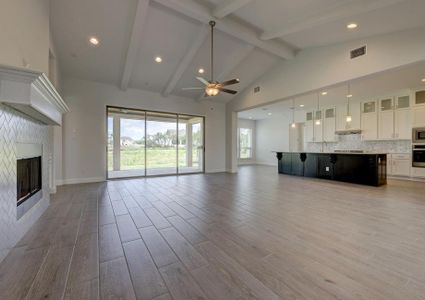 Open layout with the spacious family room peering out onto the back yard through large glass windows.