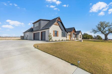 View from driveway facing front of home & west side of home featuring 3 car garage and upstairs bonus room space.