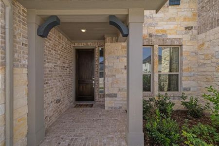 View of exterior entry featuring stone siding and brick siding