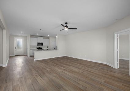 Spacious family room with plank flooring and a ceiling fan