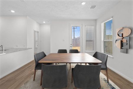 Start your day off right with a cup of coffee sitting with your family in the lovely breakfast/dining area! Featuring large windows with blinds, custom neutral paint, vinyl plank flooring, recessed lighting and high ceilings!