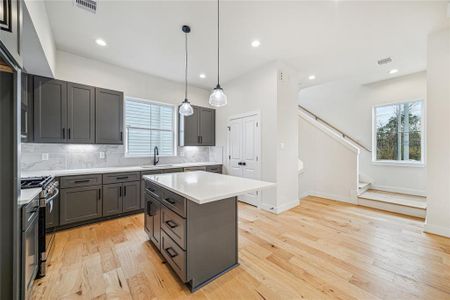 Welcome to a bright and inviting entrance, featuring elegant hardwood floors and a sleek staircase, setting the tone for modern living.