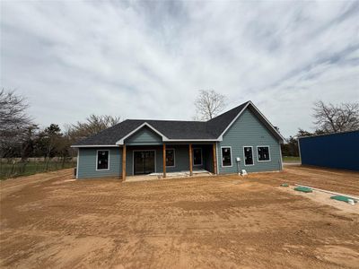 View of front of property featuring covered porch and a shingled roof