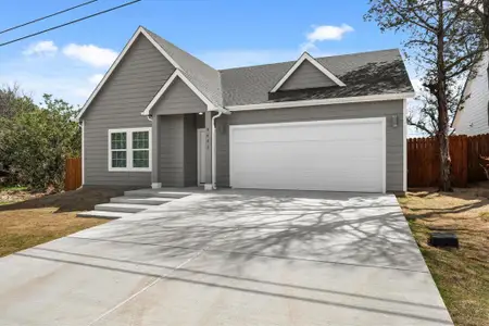 View of front of property featuring concrete driveway, roof with shingles, a garage, and fence