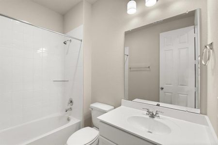 The secondary bath features tile flooring, white cabinetry and light countertops and a shower/tub combo. Perfect for accommodating any visiting family and friends.