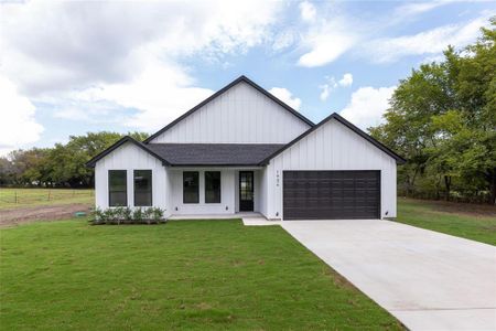 Modern farmhouse style home with a garage and a front yard