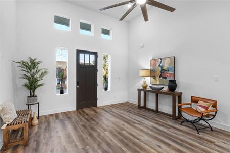 Foyer entrance with a high ceiling, hardwood / wood-style floors, and ceiling fan