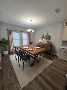 Dining space featuring an inviting chandelier and dark hardwood / wood-style floors