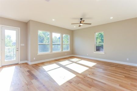 Spare room featuring light hardwood / wood-style flooring, a wealth of natural light, and ceiling fan