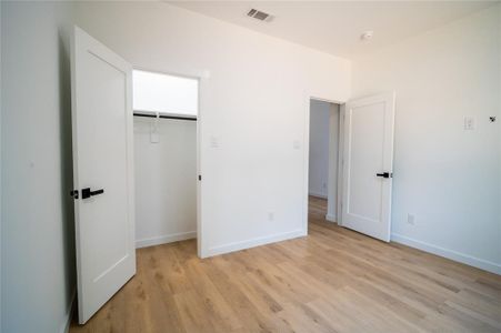 Unfurnished bedroom featuring a closet and light wood-type flooring