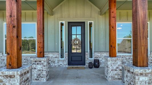 Doorway to home featuring covered porch