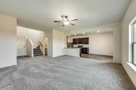 Living room with ceiling fan and light carpet