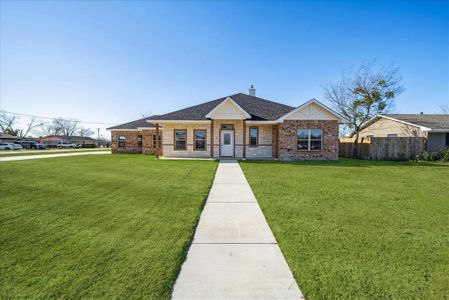 Ranch-style house featuring covered porch and a front lawn