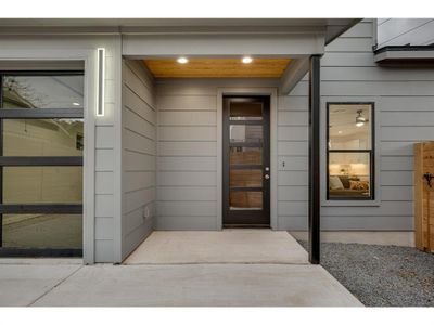 A cozy front porch featuring a warm, wood-planked ceiling and recessed lighting.