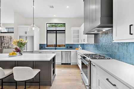 Sleek white shaker style cabinets pop against the gorgeous moroccan blue tile backsplash.