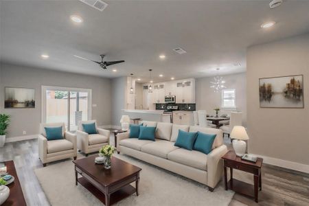 Living room with sink, ceiling fan with notable chandelier, and hardwood / wood-style floors