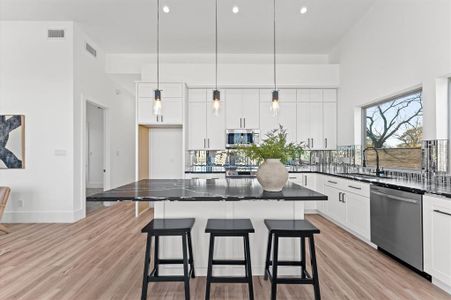 The kitchen is a true showstopper, featuring an 8-foot island, sleek modern finishes, and ample cabinet space