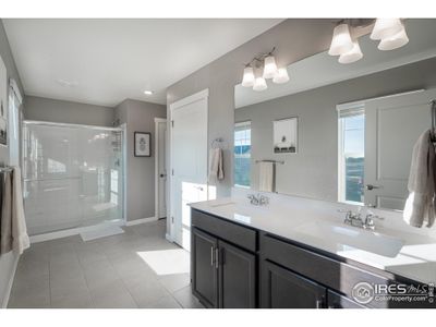 Spacious primary bathroom with quartz counters and extra storage.