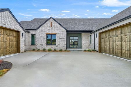 Double iron french doors and 3 car garage