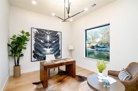 Office area with light hardwood / wood-style flooring and a notable chandelier