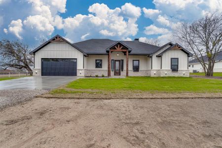 Modern farmhouse style home featuring a front yard and a garage