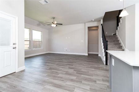 Unfurnished living room featuring ceiling fan and light wood-type flooring